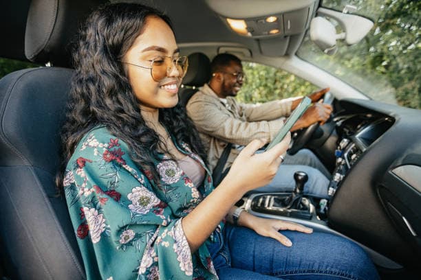 Illustrative passenger using a mobile phone during an e-hailing trip